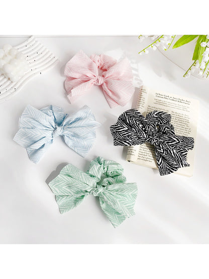 Chic striped bow scrunchie in beige and white fabric on a white background