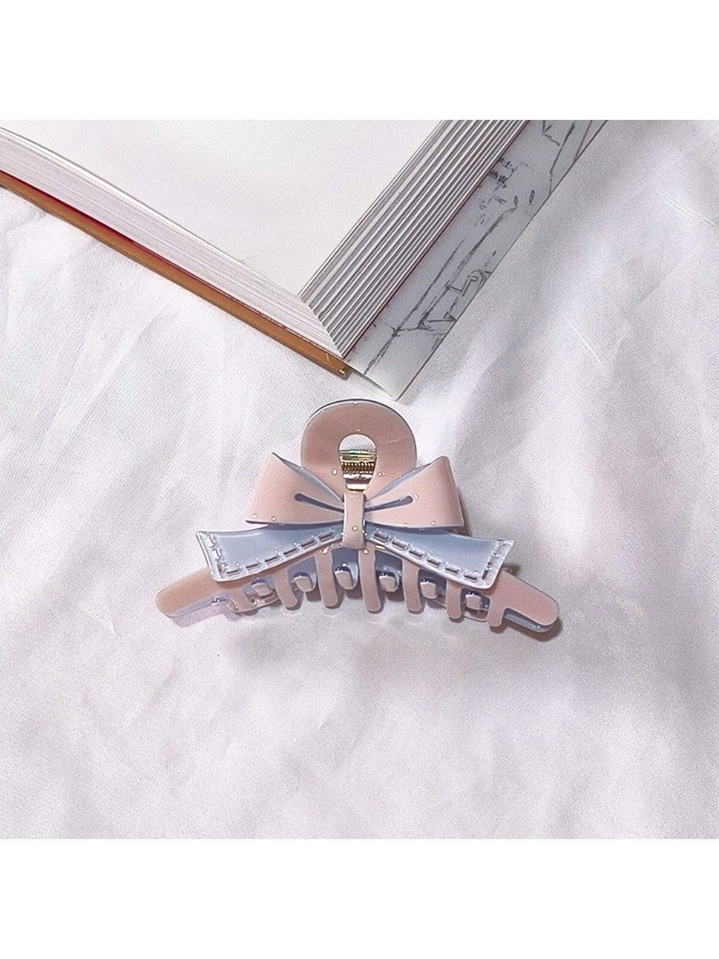 Beau acetate bow shaped claw clip shown in natural outdoor setting