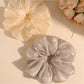 Gifty scrunchie displayed on a white surface highlighting its shiny texture