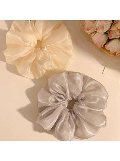 Gifty scrunchie displayed on a white surface highlighting its shiny texture