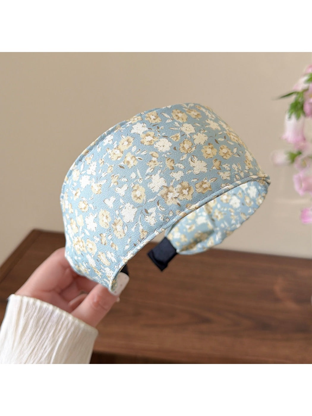 Folded cute headband showing detailed stitching and countryside floral print