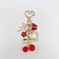 Side view of cherry bow charm keychain highlighting the glossy finish on cherries