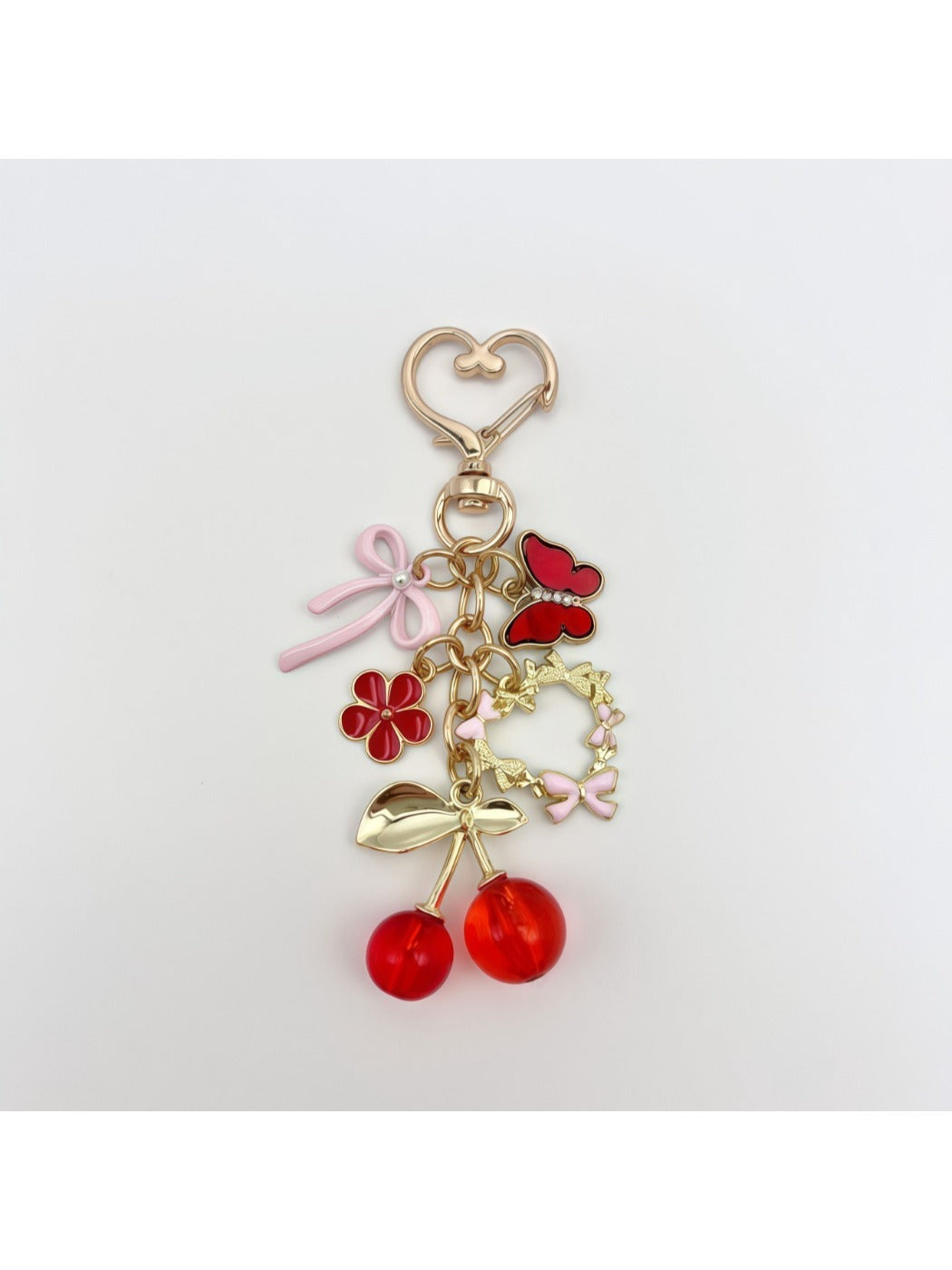 Side view of cherry bow charm keychain highlighting the glossy finish on cherries