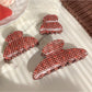 Beau hair claw clip open, displaying teeth and strawberry plaid fabric