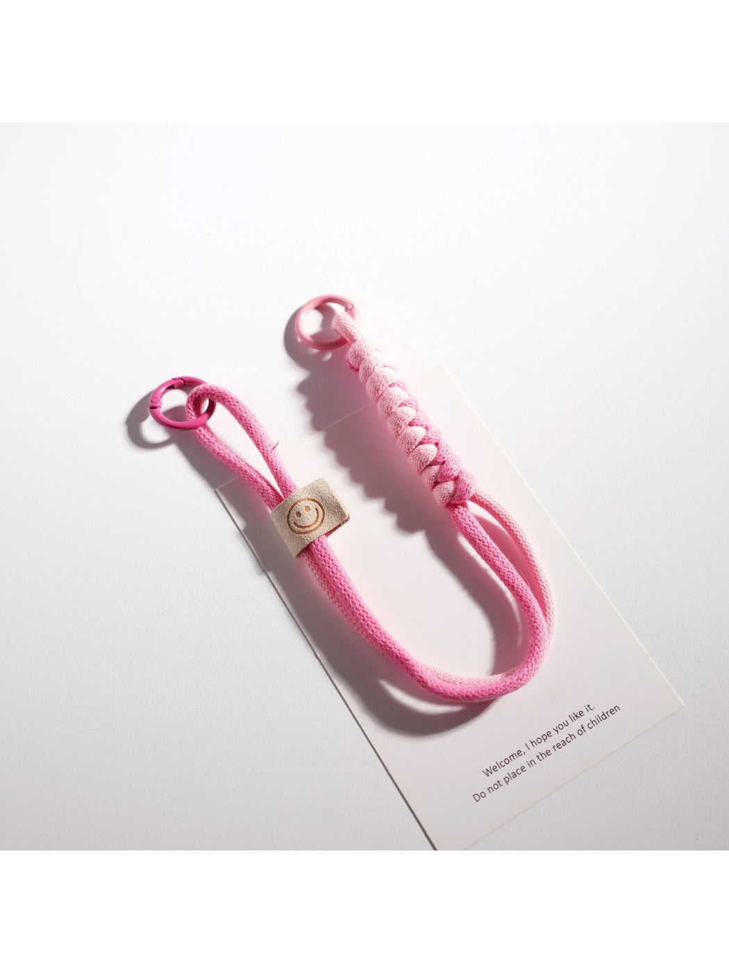 Brightly colored rope keychain with silver ring on wooden table