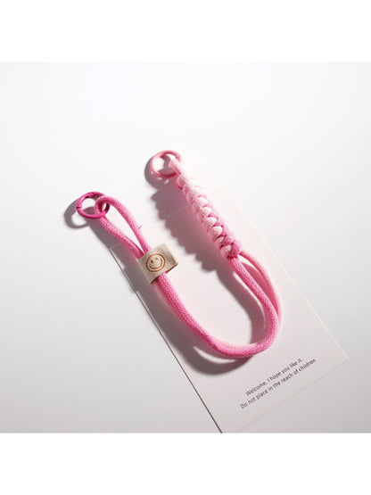 Brightly colored rope keychain with silver ring on wooden table