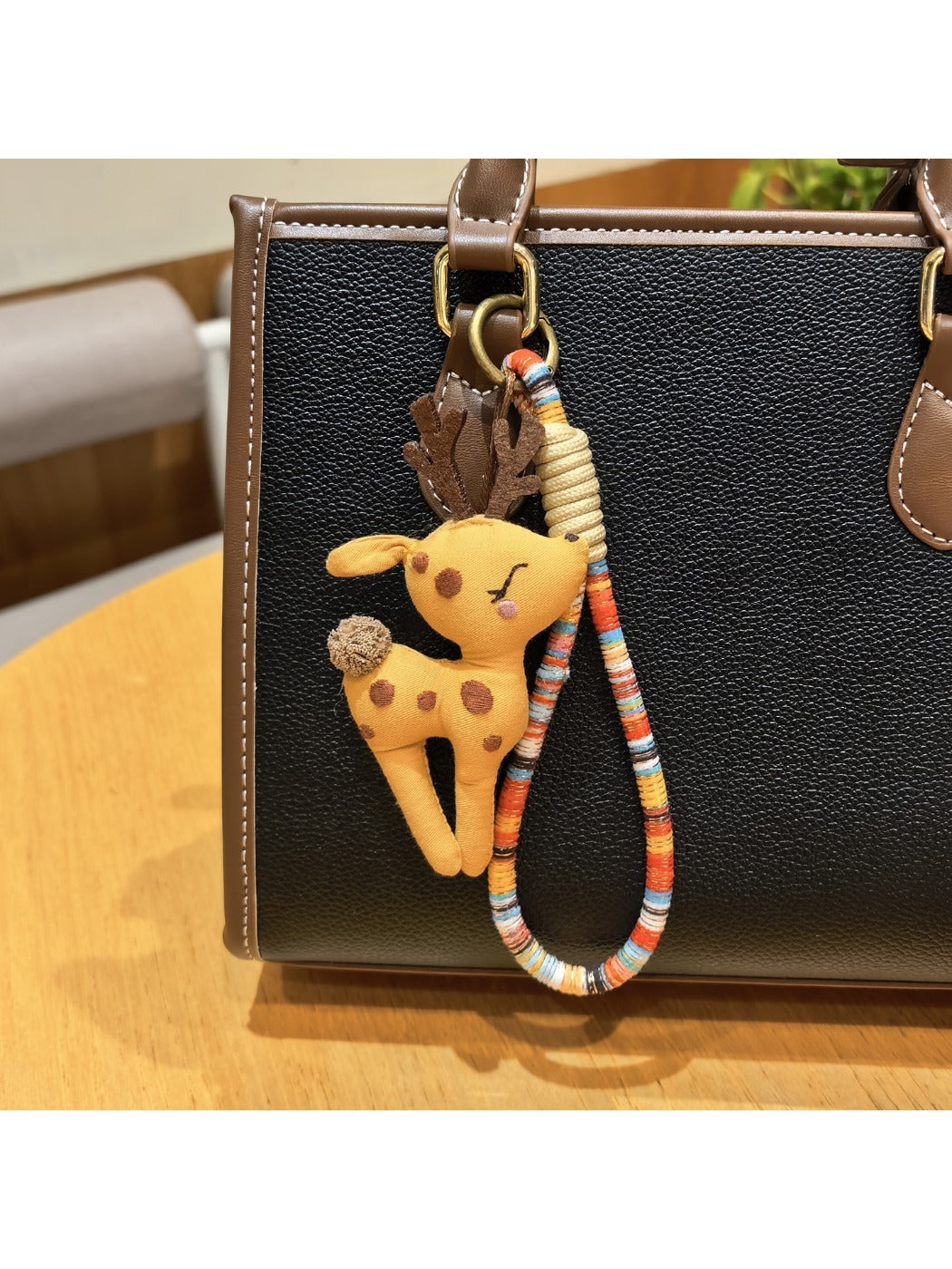 Keypus deer charm keychain attached to a set of keys on a desk
