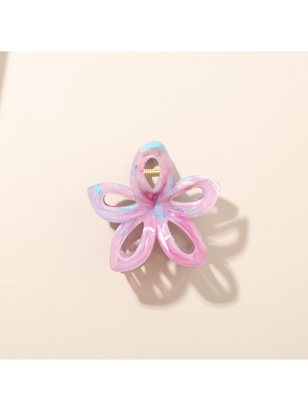 Beau colorful flower hair clip placed on a wooden surface