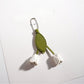Tulip flower keychain hanging from a set of keys on a wooden surface
