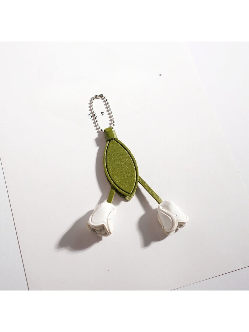 Tulip flower keychain hanging from a set of keys on a wooden surface