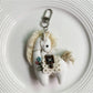 Fabric pony bag charm keychain displayed with other colorful accessories