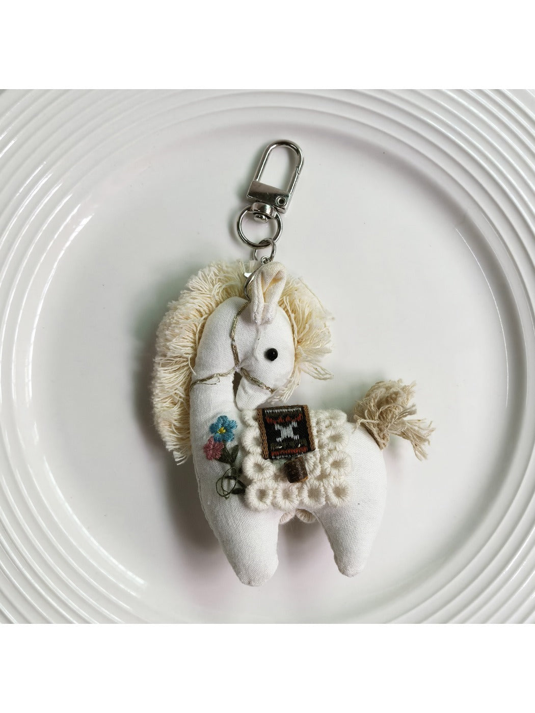 Fabric pony bag charm keychain displayed with other colorful accessories