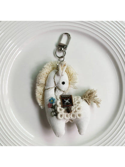 Fabric pony bag charm keychain displayed with other colorful accessories