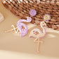 Pair of cute flamingo pendant earrings displayed on a jewelry card