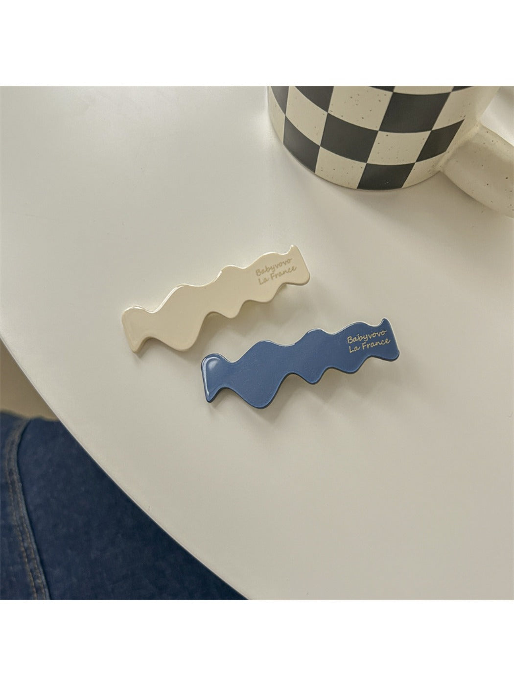 Beau hair clip open to reveal metal clasp mechanism and blue floral design
