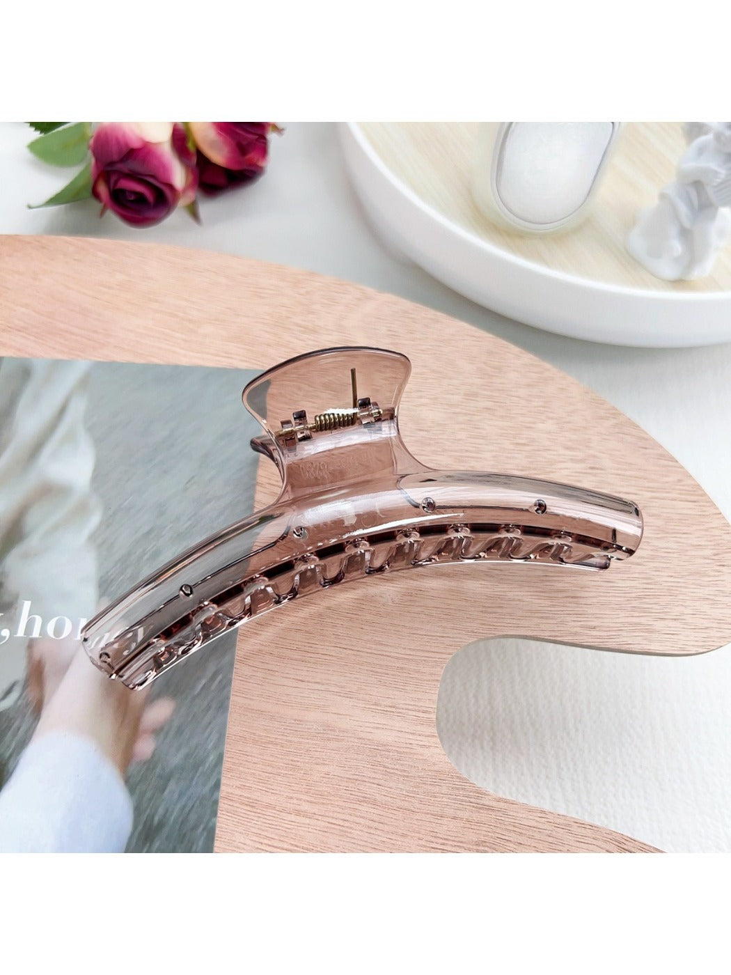 Pastel curved claw clip with curved design resting on marble background