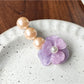 Beau Camellia shaped hair clip with white beads against a dark background