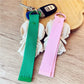 Fabric patchwork woven strap keychain held in hand displaying size and texture