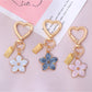 Keypus floral charm keychain hanging from a set of keys on a wooden surface