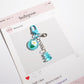 Keypus cartoon keychain hanging from a handbag strap