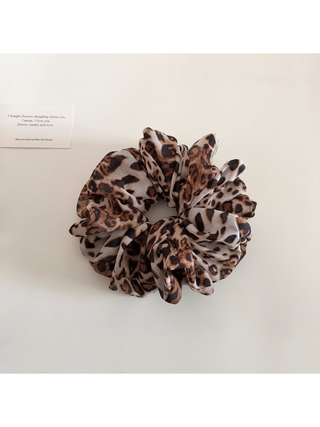 Scrunchie with vintage leopard print worn on wrist as a bracelet