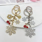Snowflake pendant keychain hanging from a silver keyring with a white backdrop