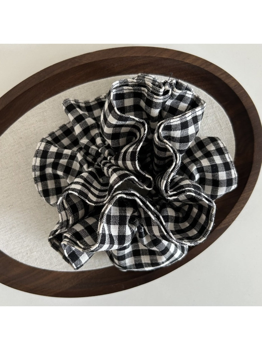 Black and white check vintage scrunchie held in hand showing size