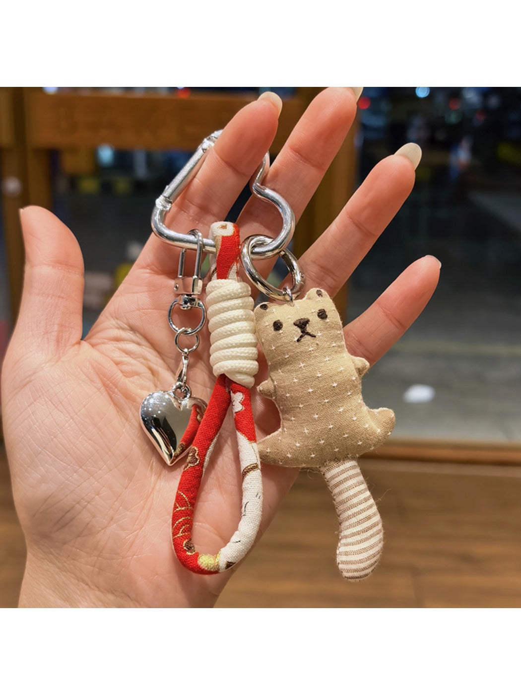 Bear keychain held in hand showing its compact size and softness