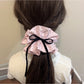Side view of Gifty sweet polka dot bow scrunchie highlighting fabric texture and elastic band