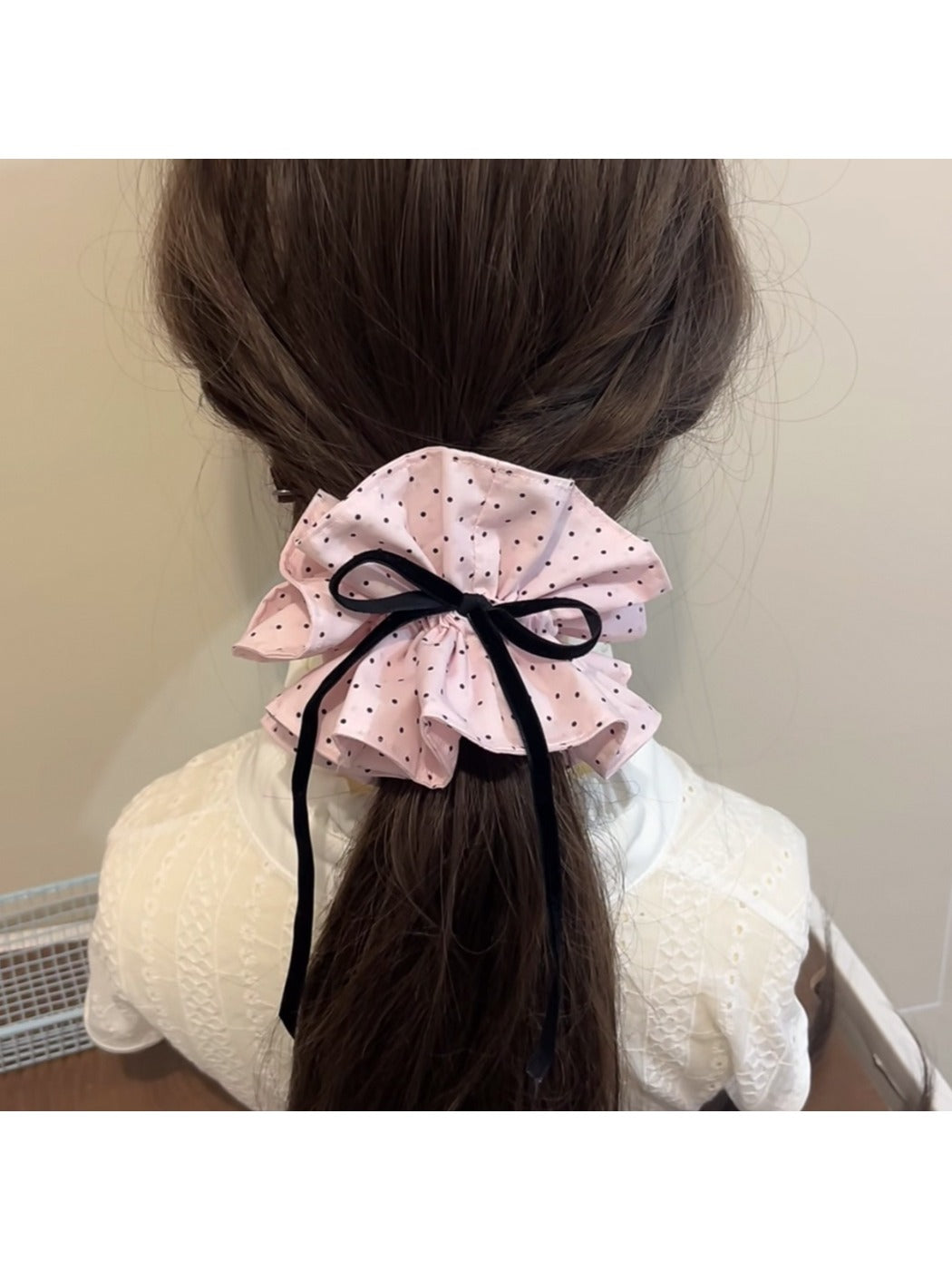 Side view of Gifty sweet polka dot bow scrunchie highlighting fabric texture and elastic band