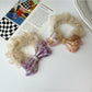 Side view of Gifty scrunchie showing mesh bow detail and acetate material