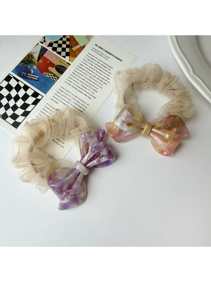 Side view of Gifty scrunchie showing mesh bow detail and acetate material