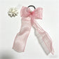 Plaid tulle bow hair tie displayed with matching accessories on wooden surface