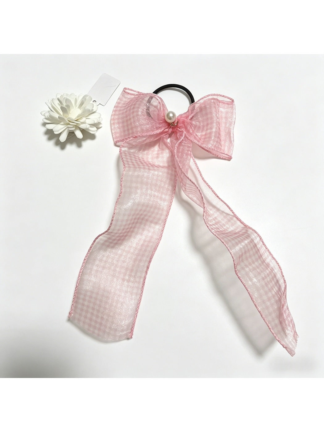 Plaid tulle bow hair tie displayed with matching accessories on wooden surface