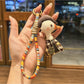 Duck charm keychain attached to a set of keys on a wooden surface