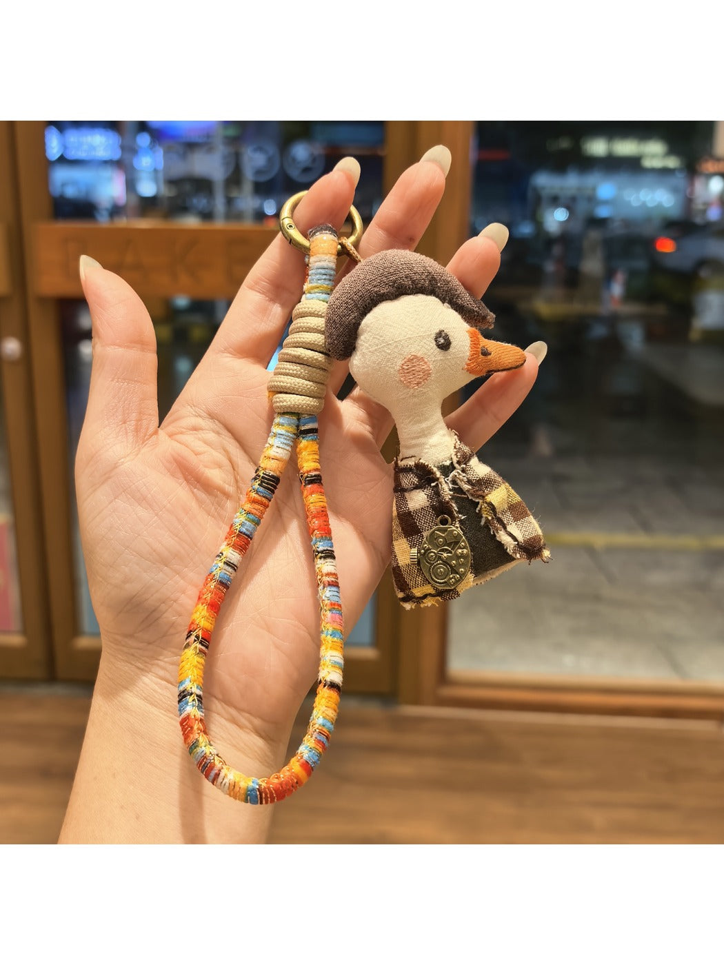 Duck charm keychain attached to a set of keys on a wooden surface