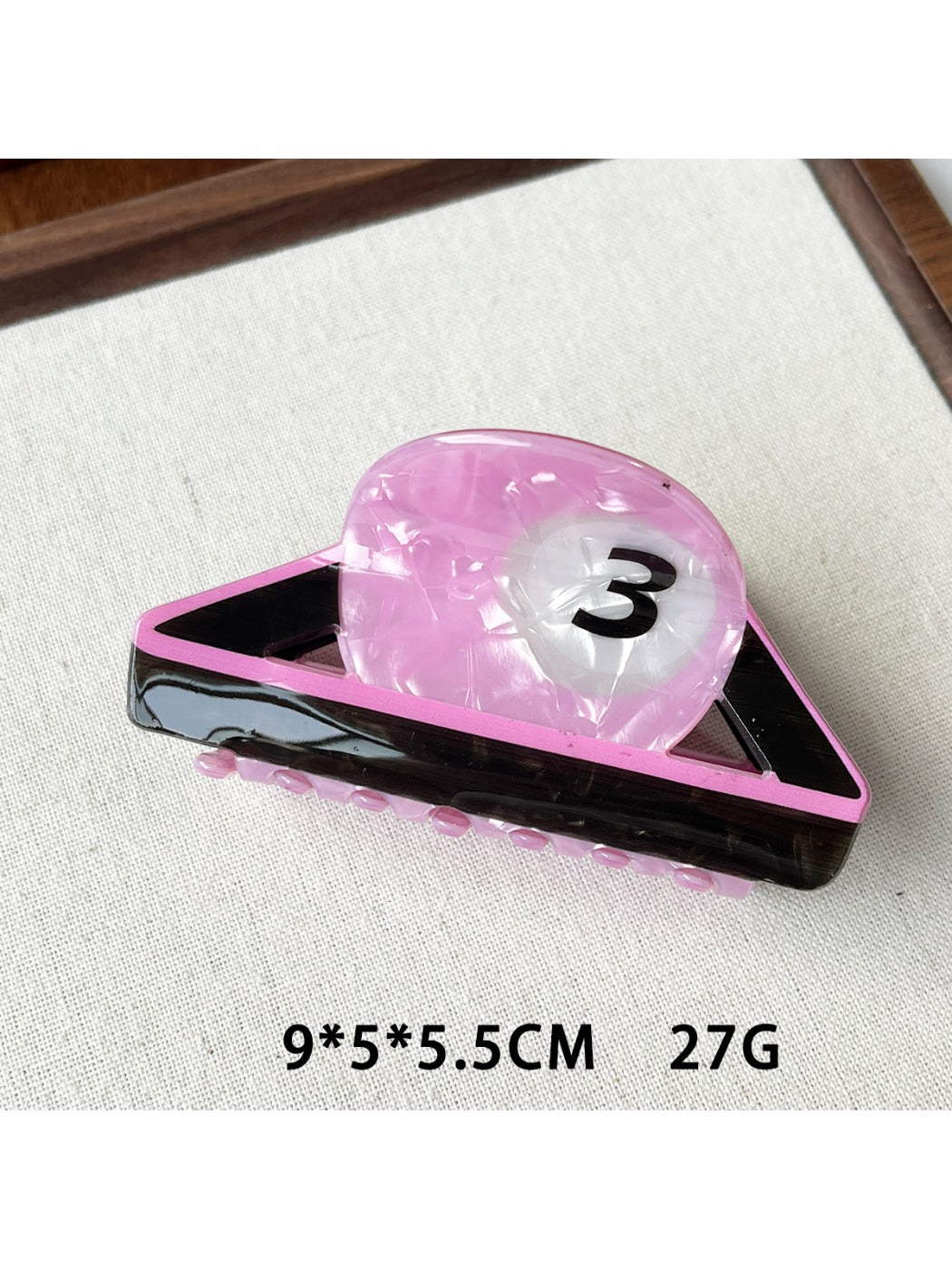 Beau claw clip shaped like a basketball shown from an angled perspective