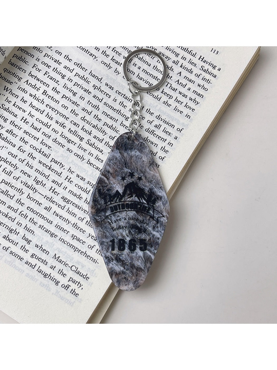 Colorful diamond-shaped pendant keychain on a black background emphasizing colors
