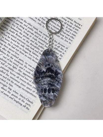 Colorful diamond-shaped pendant keychain on a black background emphasizing colors