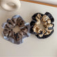 Side view of Gifty color block scrunchie highlighting fabric texture and elastic band