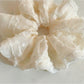 Side view of the ruffled scrunchie showing its texture and fabric folds
