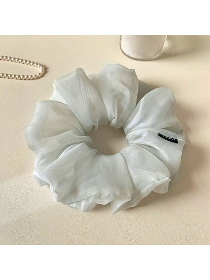 Grey ruched scrunchie displayed flat showing fabric texture and gathers