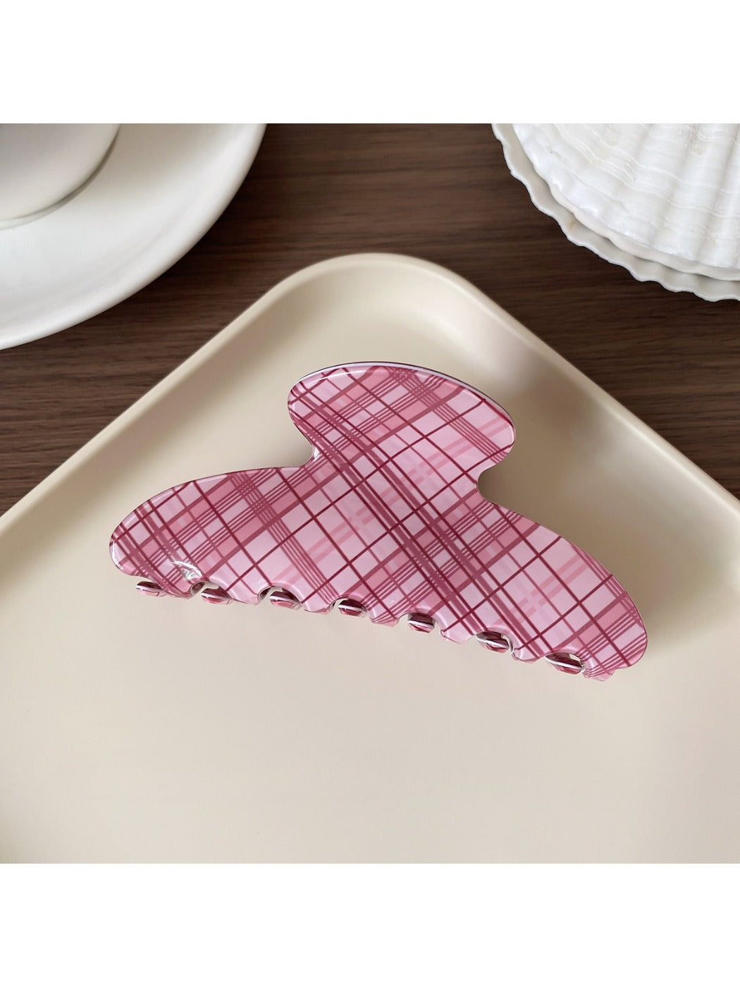 Beau pink plaid hair claw clip displayed on wooden surface
