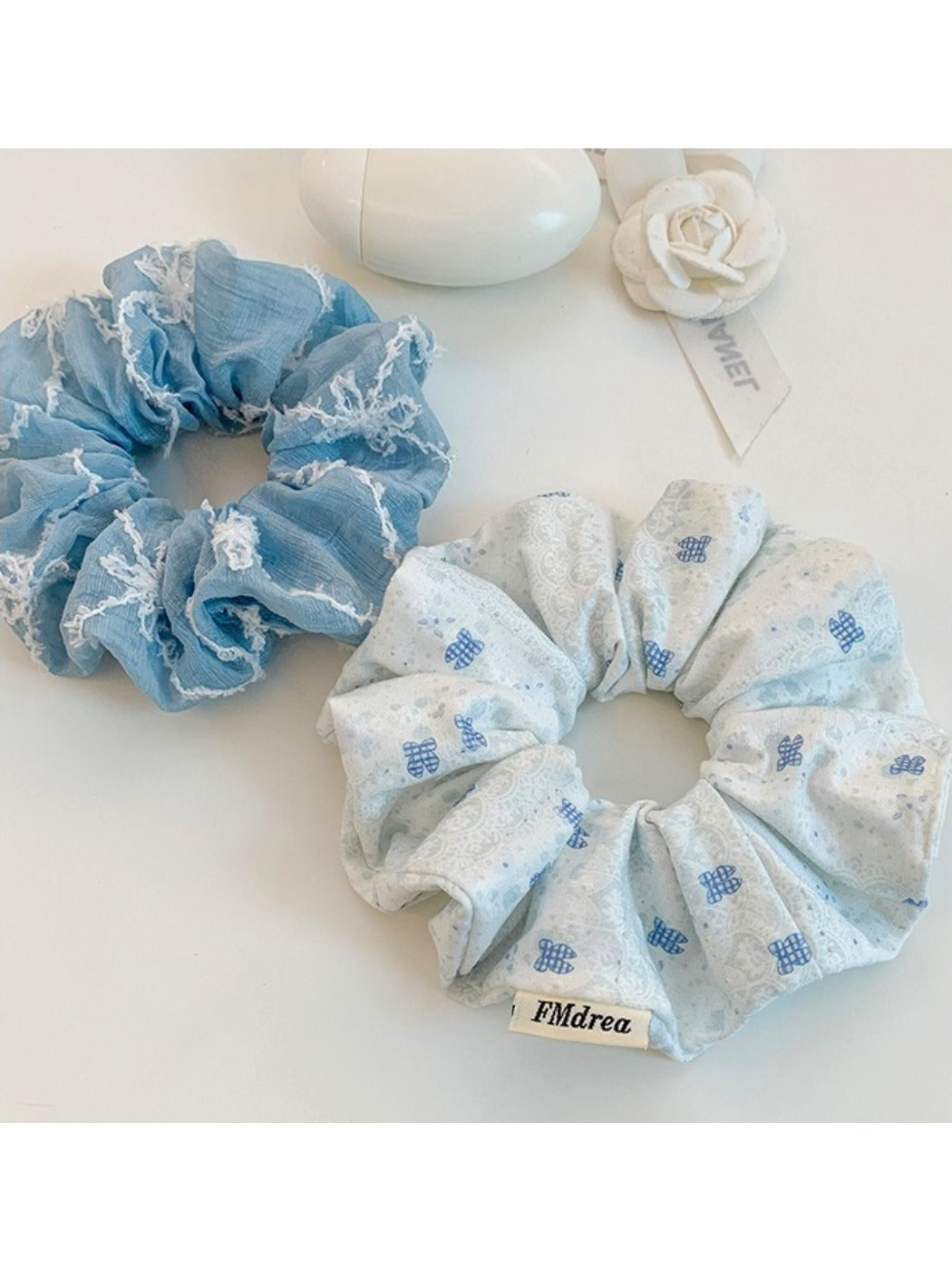 Blue bow print scrunchie displayed on a wooden surface