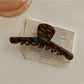 Beau chic acetate claw clip clipped into thick curly hair