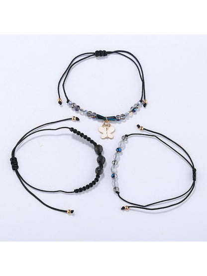 Lovra bracelet featuring butterfly pendant and small gold beads on wrist