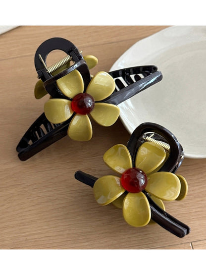 Side view of beige flower-shaped claw clip highlighting the clasp mechanism