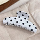 Beau polka dot half circle claw clip displayed on a white surface