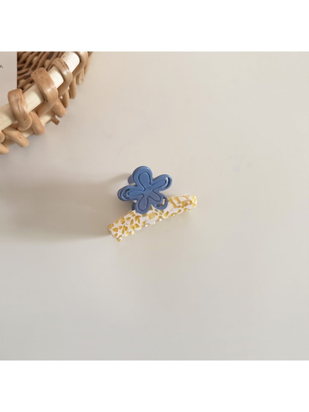 Beau fresh acetate flower hair clip with light reflecting off its smooth surface