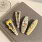 Close-up of yellow floral hair clip showing detailed fabric texture and flower pattern